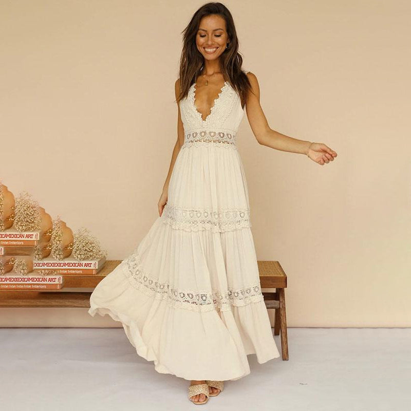Woman in cream maxi dress with lace accents, standing in a rustic room with books and vases.