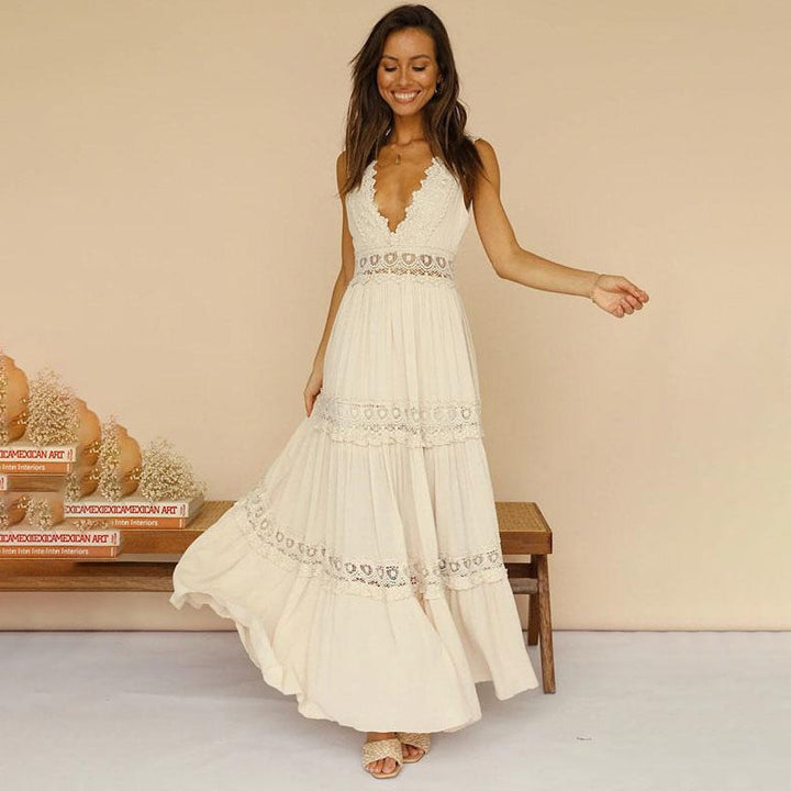 Woman in cream maxi dress with lace accents, standing in a rustic room with books and vases.