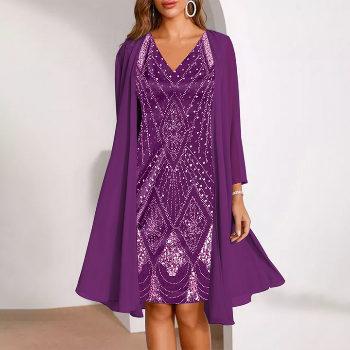 Elegant two-piece dress in rich purple with detailed patterns, complemented by a flowing cardigan. Studio background.