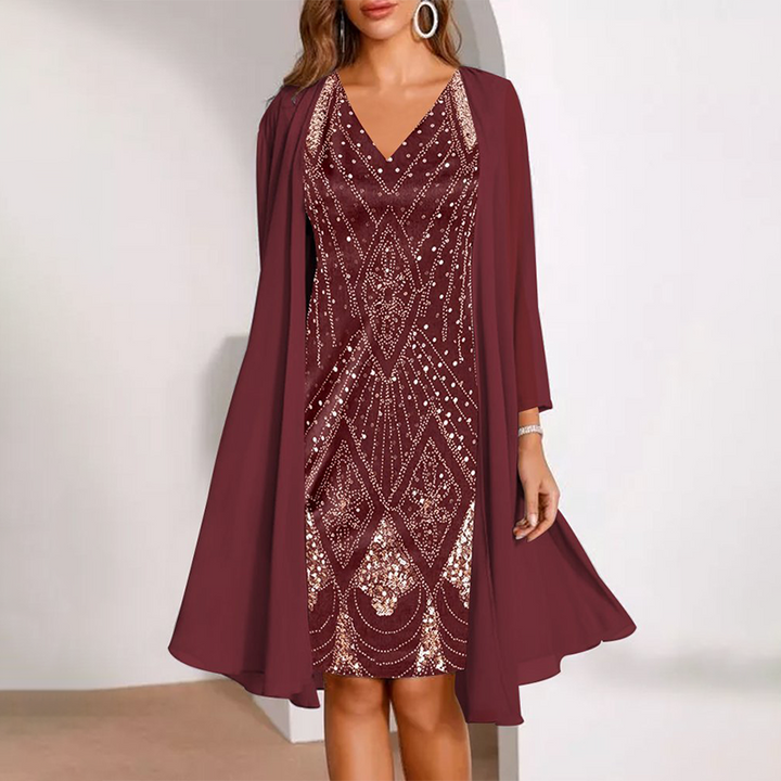 Elegant two-piece dress in deep red with intricate patterns, paired with a flowing cardigan. Studio background.