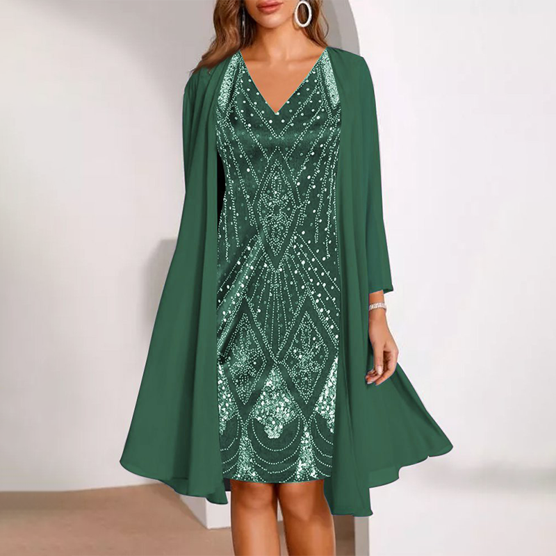 Elegant two-piece dress in deep green with elaborate patterns, matched with a flowing cardigan. Studio background.
