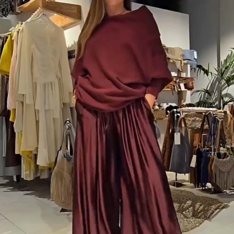 Person wearing a burgundy off-shoulder set in a boutique with hanging clothes and bags.