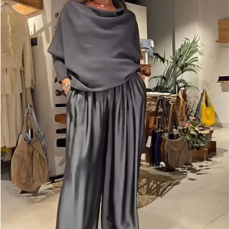 Person wearing a gray off-shoulder set, standing in a boutique with accessories.