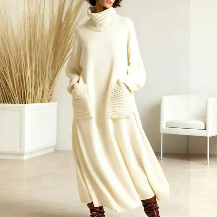 Stylish cream sweater dress featuring a high neck and spacious pockets, displayed in a simple indoor setting with light decor and a white chair.