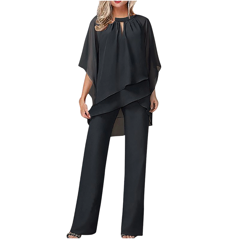 Black elegant set with layered top and wide-leg pants in a studio setting.