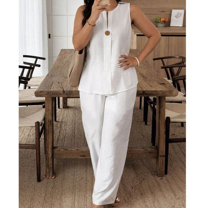 Stylish white sleeveless top and pants ensemble displayed in a homey dining room featuring a wooden table and chairs.