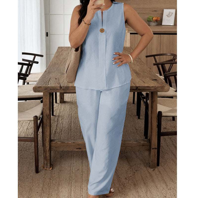 Light blue sleeveless top and pants set modeled in a comfortable indoor dining space with wooden furniture and soft flooring.