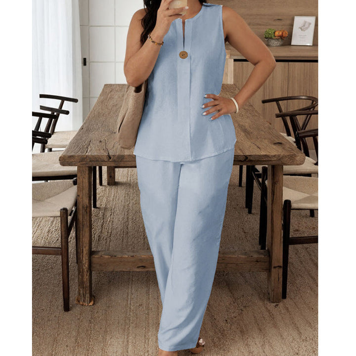 Light blue sleeveless top and pants set modeled in a comfortable indoor dining space with wooden furniture and soft flooring.