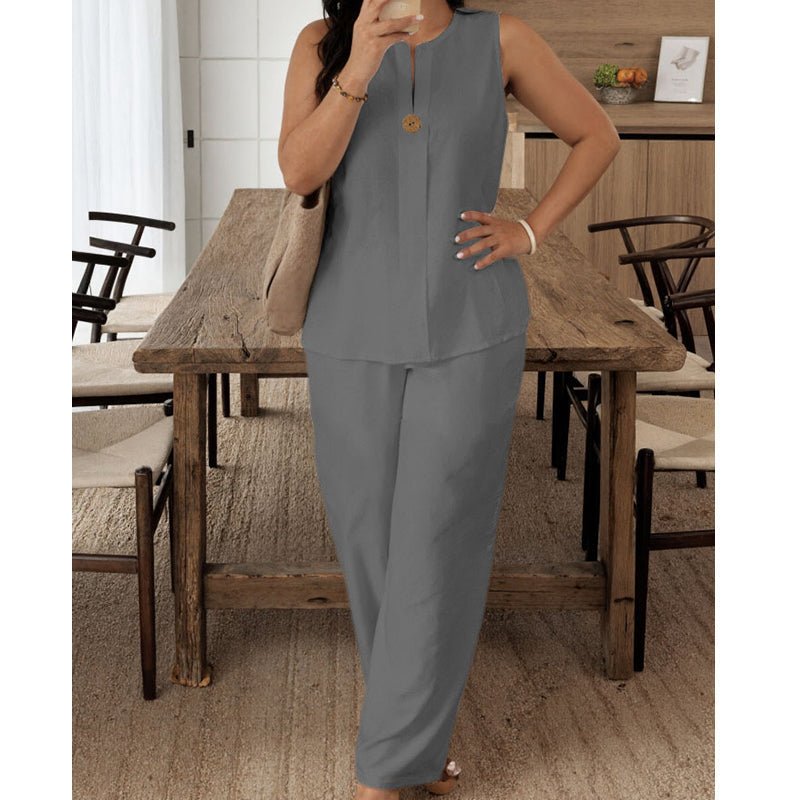 Sleek gray sleeveless top and pants showcased in a rustic dining room setting with a wooden table and chairs.