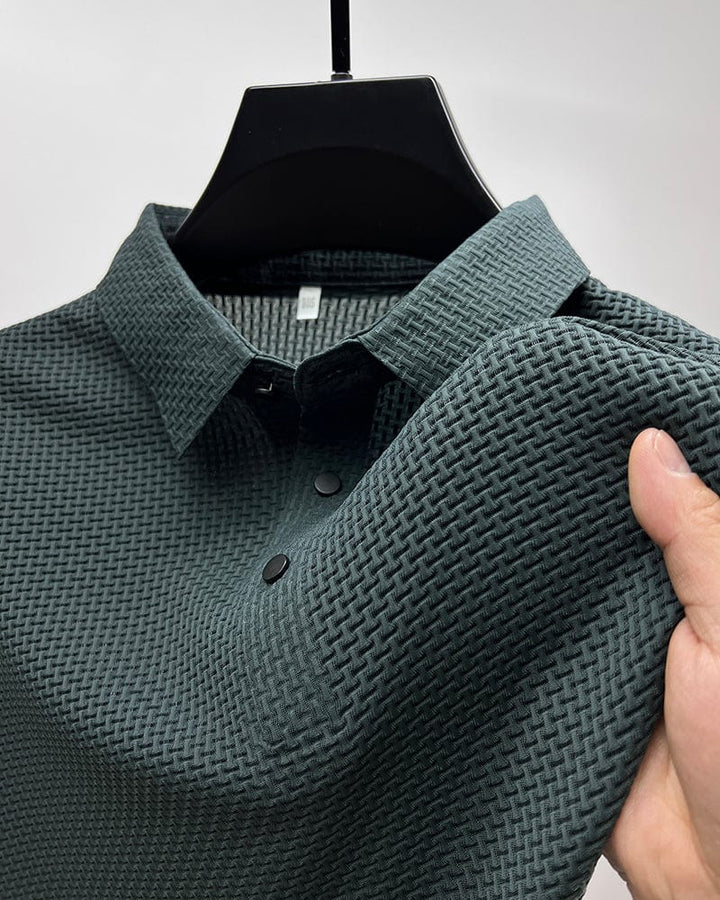 Teal textured polo shirt on hanger, close-up of collar and buttons, hand touching fabric in studio.