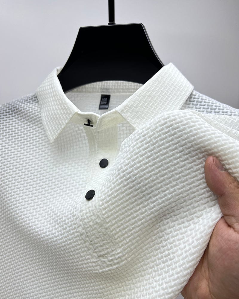 White textured polo shirt on hanger, close-up of collar and buttons, hand touching fabric in studio.