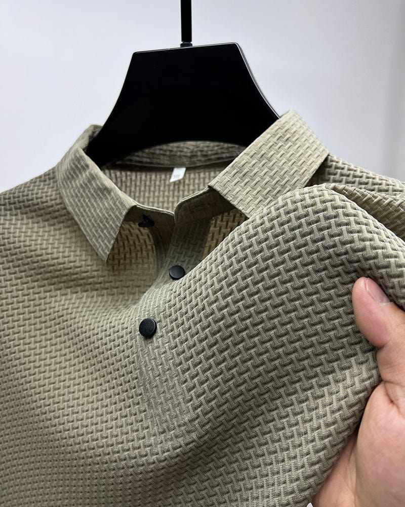 Beige textured polo shirt on hanger, close-up of collar and buttons, hand touching fabric in studio.