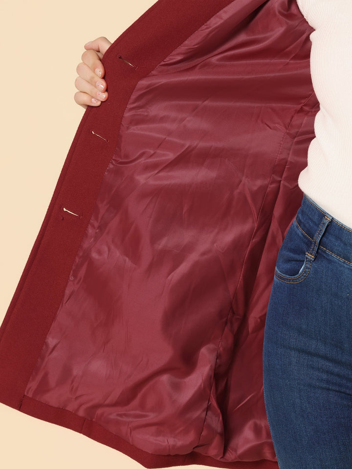 Inside view of a maroon coat lining, held open by a person wearing jeans.